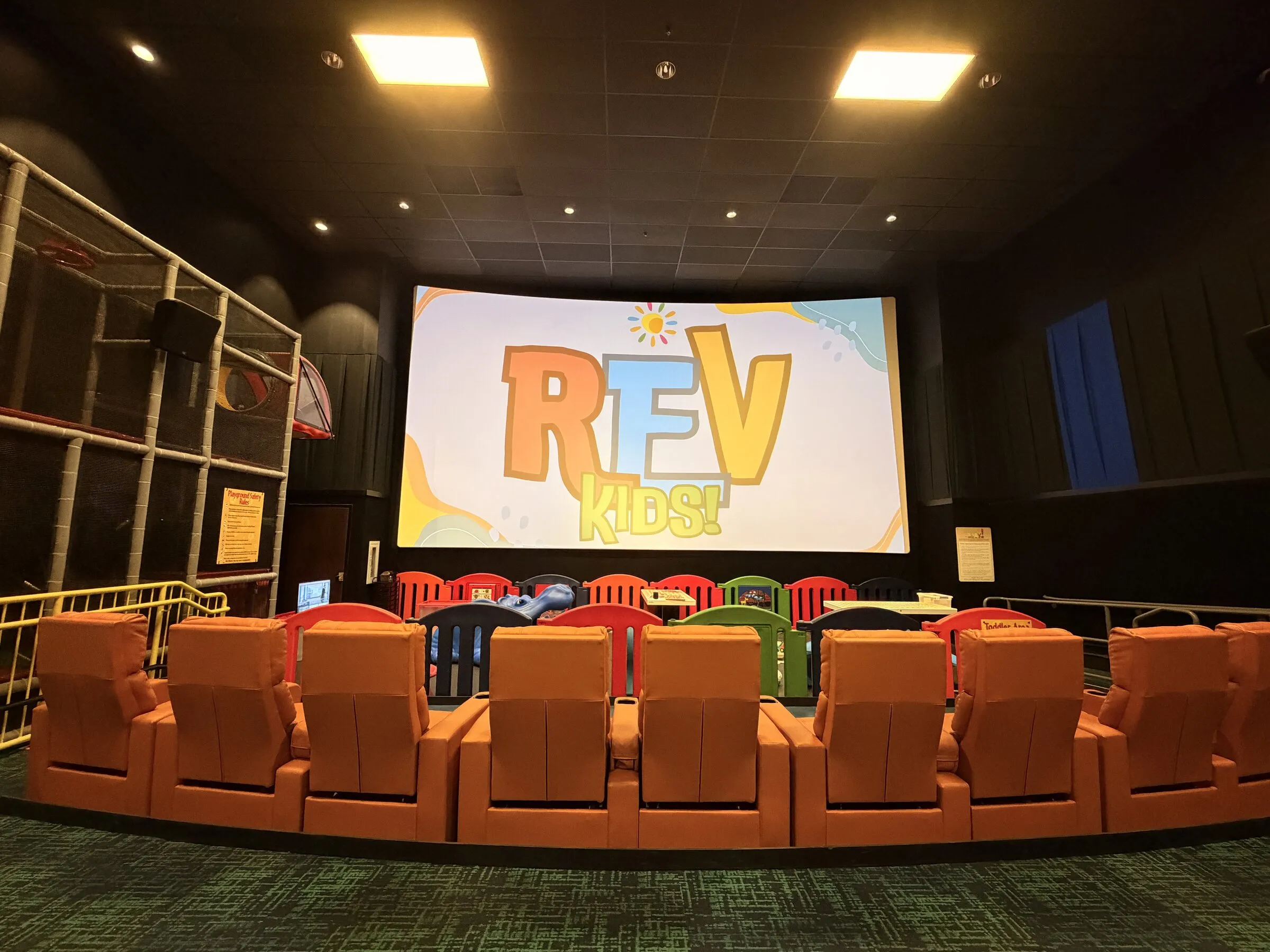 The RevKids theater with colorful seats and the RevKids logo on screen